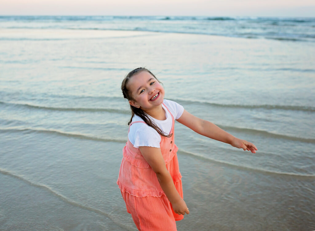 girl smiling in the waves on the beach